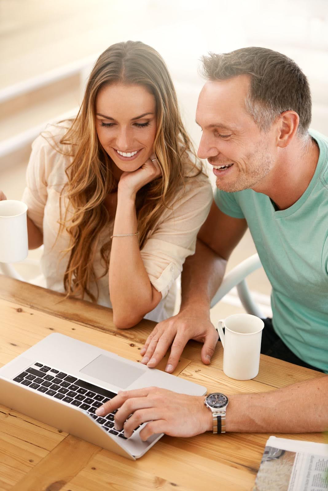 A young married couple reviews finances on a laptop