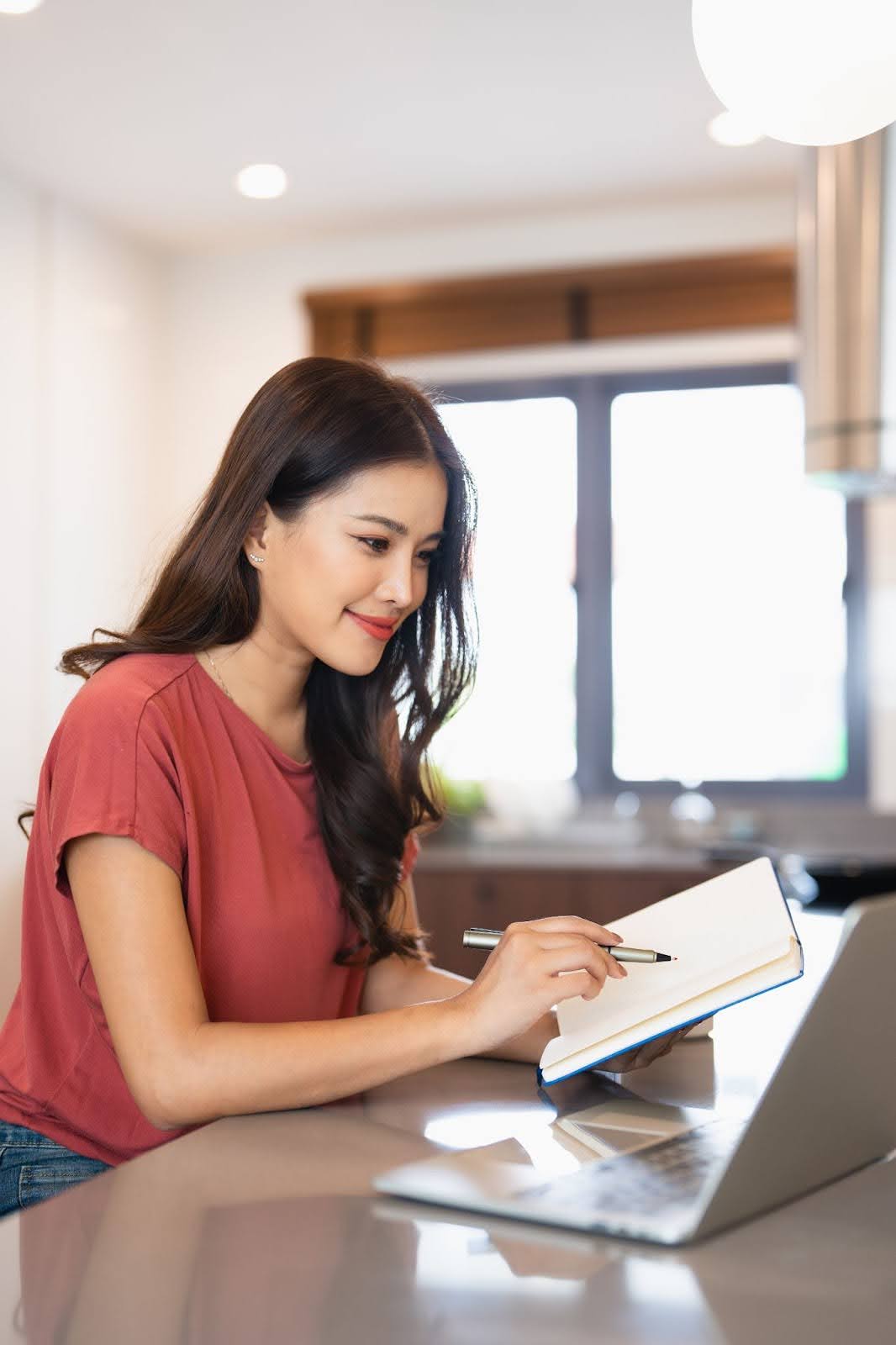 A young woman researching infinite banking on a laptop